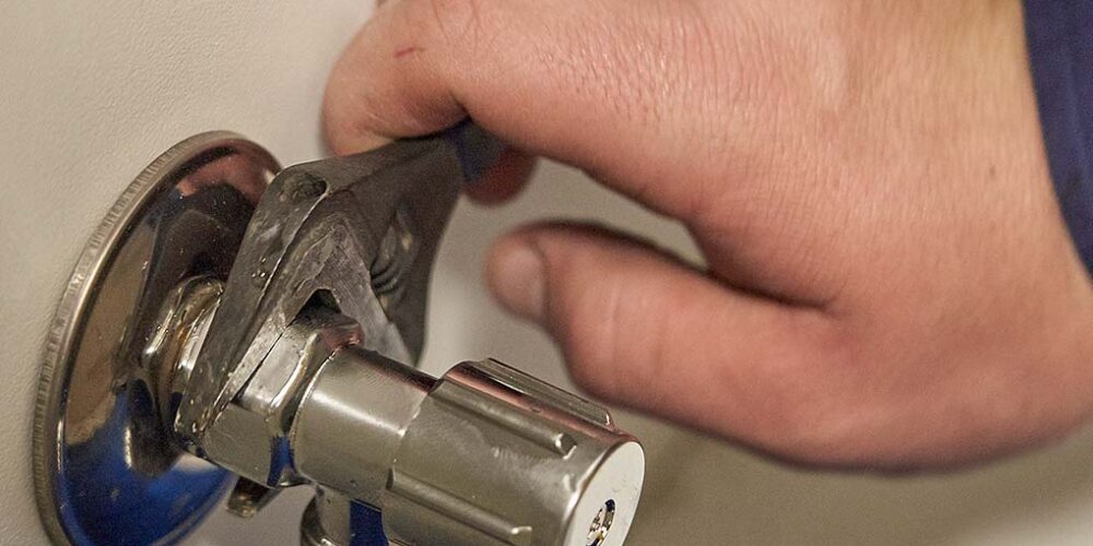 An Urban Plumbing staff member adjusting a tap